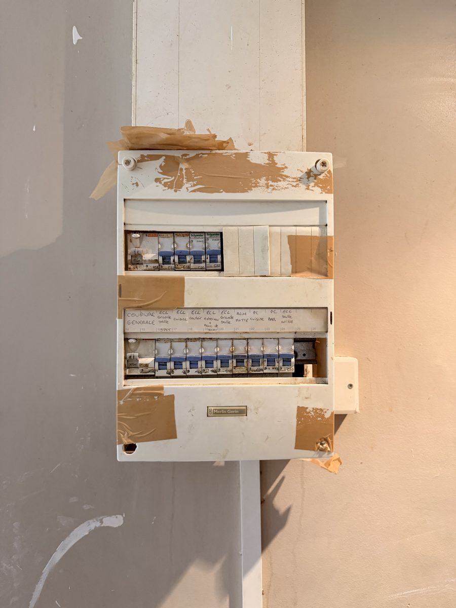 Ancien tableau électrique installé dans une niche murale