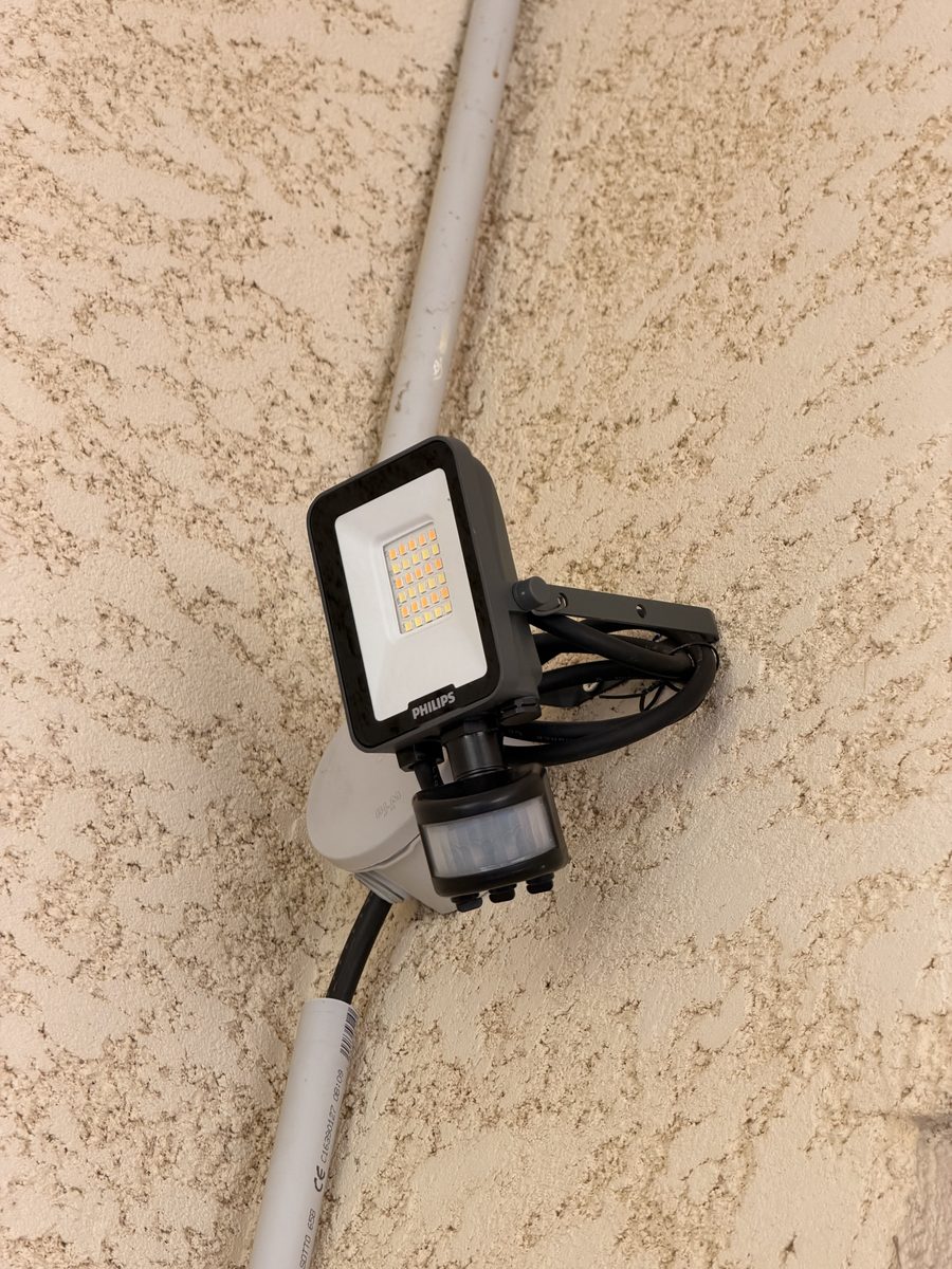 Projecteur LED posé sur façade avec câble en attente